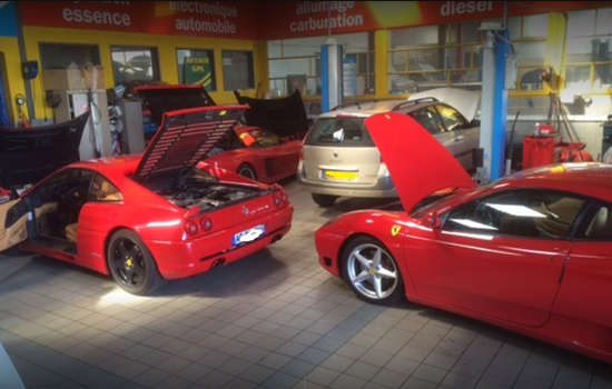 Trois Ferrari capot ouvert dans le garage